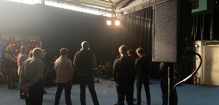People standing in facility with speakers